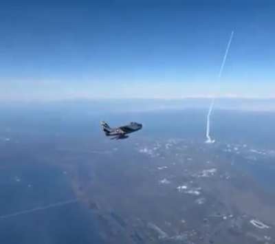 The Atlas-V rocket was launched from Cape Canaveral, FL today. An F-86 fighter jet flying by managed to capture the launch.