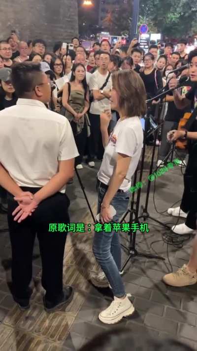 西安城墙下<wbr>，南门巴士<wbr>乐队在演唱<wbr>《活着》，<wbr>因把歌词“<wbr>他们拿着苹<wbr>果手机”改<wbr>成“华为手<wbr>机”，遭致<wbr>一名游客不<wbr>满质问不应<wbr>该修改歌词<wbr>…乐队女子<wbr>反驳：我们<wbr>拿着华为手<wbr>机有错吗？<wbr>怼的游客哑<wbr>口无言