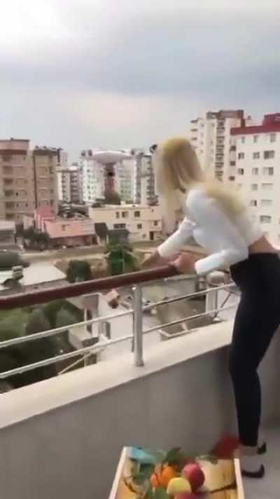 Woman tries to grab item hanging from a drone, it loses control and crashes in her head