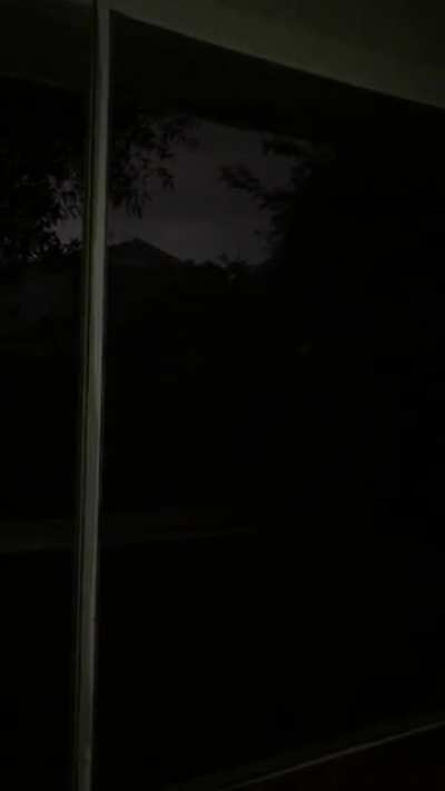 Dark rainstorm on an old Florida lanai with low lying thunder, and anoles/frogs you can’t see on the screen