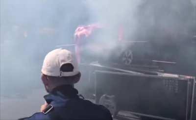 Protesters in Paris, France, set an American flag and cardboard Tesla on fire