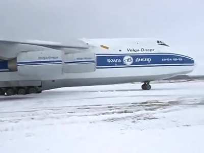 Antonov overshot runway and got stuck in the mud. Emergency services dispatched but the Pilot decided to get it out on his own and almost killed a man.
