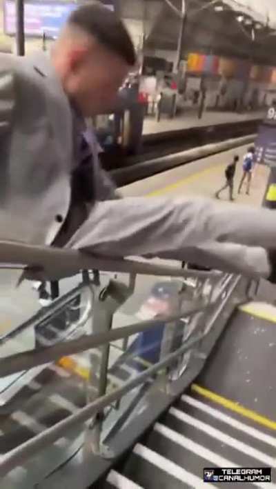 Man falls trying to slide down a handrail.