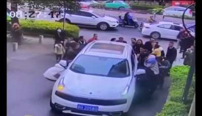 Crowd saves a girl that got ran over and trapped under a car in China