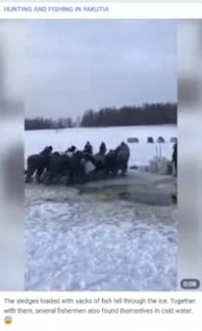 Fishermen pushing a sled full of fish across the ice.