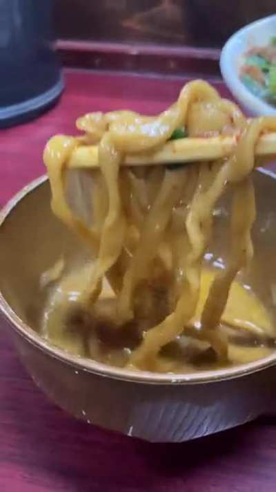 Dipping thick ramen noodles into raw egg and gyofun fish powder at Suzuki (Tokyo)
