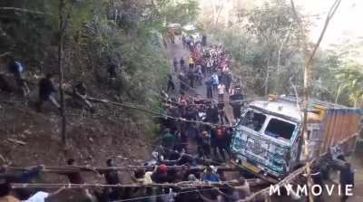 A swarm of men from Nagaland, India pulled a truck out of the valley pit.