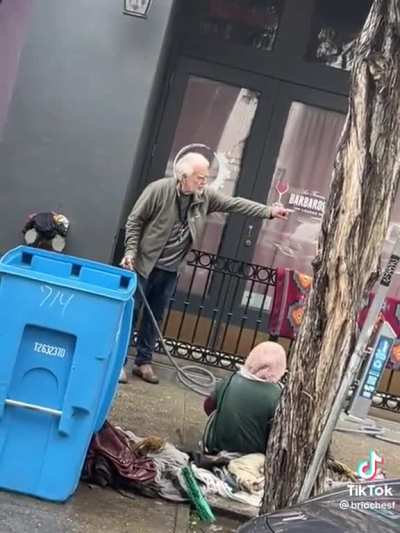 Scumbag douses homeless woman with water hose