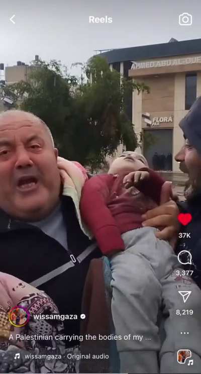 Palestinian father holding his two killed children