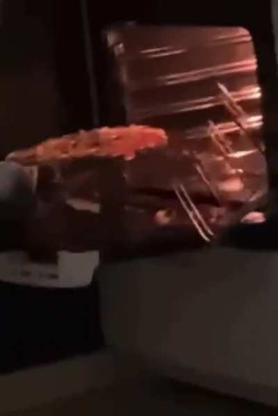 taking the pizza out of the oven