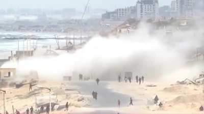 Two Israeli tanks firing on building at the side of Al-Rashid Street just north of Wadi Gaza Bridge, Gaza at 09:39 GMT (12:39 local time) on October 9th