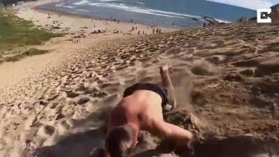 Backflips down a sand bank