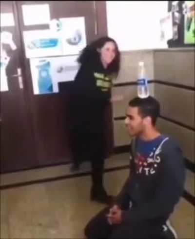 Trying to kick a water bottle off someone's head..