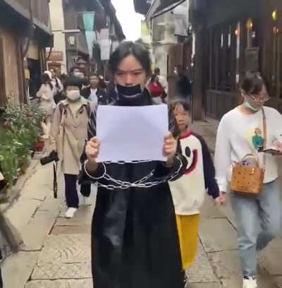 Lone female Chinese protestor protesting the CCP on the streets of Wuzhen, China