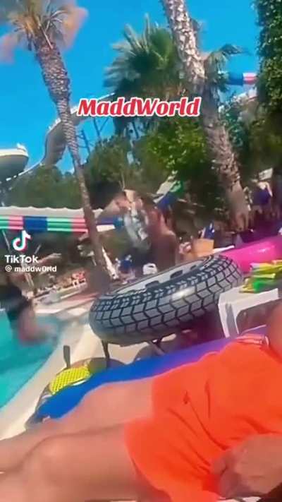 Grown man shoves a little kid into the pool.