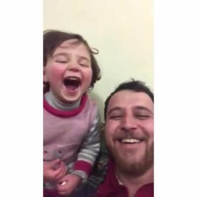 To distract his 4-year old daughter, her father has made up a game. Each time a bomb drops in Idlib Syria, they laugh, so she doesn’t get scared.