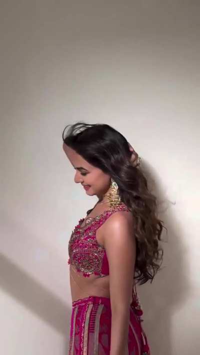 Sonal Chauhan wearing a bright pink embroidered lehenga set with intricate gold embellishments and statement dangling earrings. Sonal Chauhan,outfit is by “AUM by Ashima & Asit” and her jewellery is from Curio Cottage.