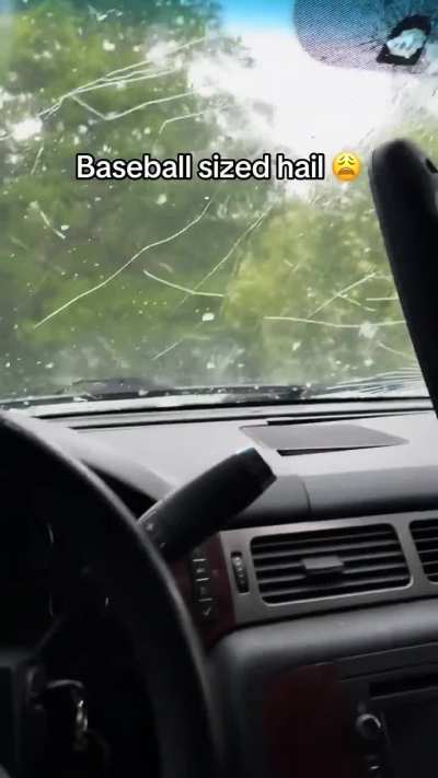 Guy gets caught in a hail storm while sitting in an SUV