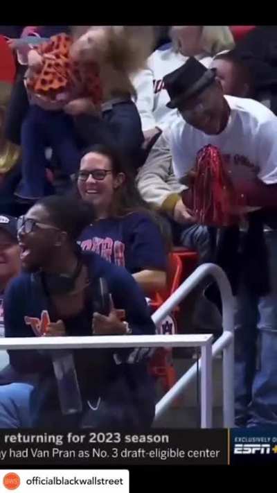 A gymnast's brother and father hype her up from the stands before she begins her routine