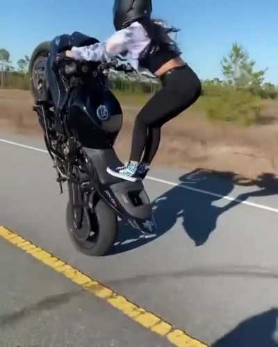 Motorcyclist showing off her wheelie skill and techniques.