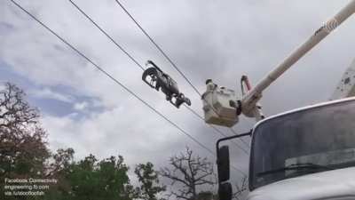 Robot for deploying aerial fiber internet that winds fiber-optic cable around existing power lines instead of underground