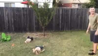 Man Teaching his daughters how to do cartwheel.