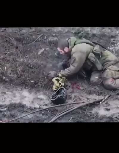Dying Ukraine soldier administering a sedative and smoking a cigarette in his last moments. 