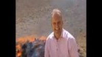 Reporter on front of a burning pile of drugs