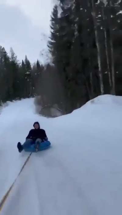 Idiot on sleigh pulled by a car