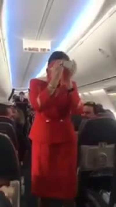 Football fans on flight distracting the air hostess doing the safety announcement