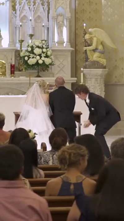 Best man fixes groom suit during wedding
