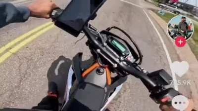 Cop drives past struggling beginner motorcycle on road