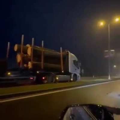 Truck hauling logs going full speed in the wrong lane