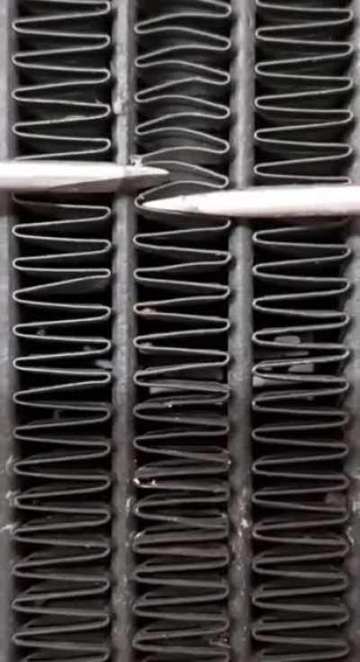 Using 2 screwdrivers to fix radiator.