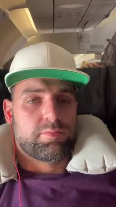 Crying child peeks over plane seat