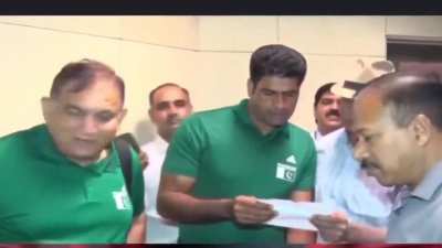 Arshad Nadeem handed a paper with script before he starts speaking with press.