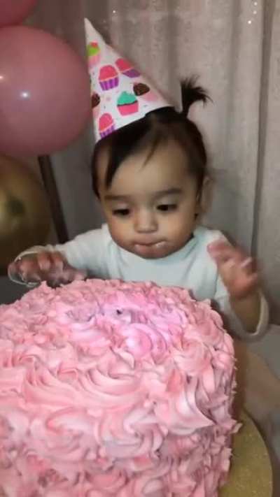 Pushing baby's face into birthday cake
