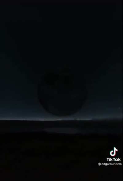The moon passing over the horizon near the North Pole
