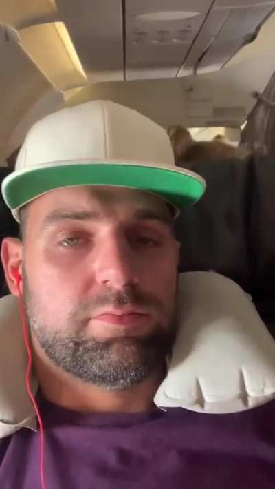 Crying child peeks over plane seat