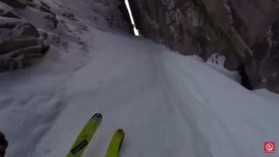 Dude skis through tiny crack in a mountain