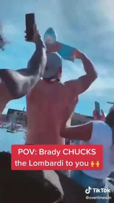 Tom Brady chucks the Lombardi trophy from his boat into another boat of partying fans