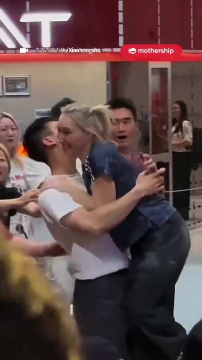 A young man blushes as Slovenian rock climber and Olympic champion Janja Garnbret stumbles off the wall and straight into his arms.