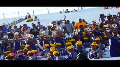 Trombone section and soloist surprise their own band with a new rendition of a song during a football game. 1 by 1, you can pinpoint when each bandmate realizes that they are listening to a legendary performance until they all explode with amazement