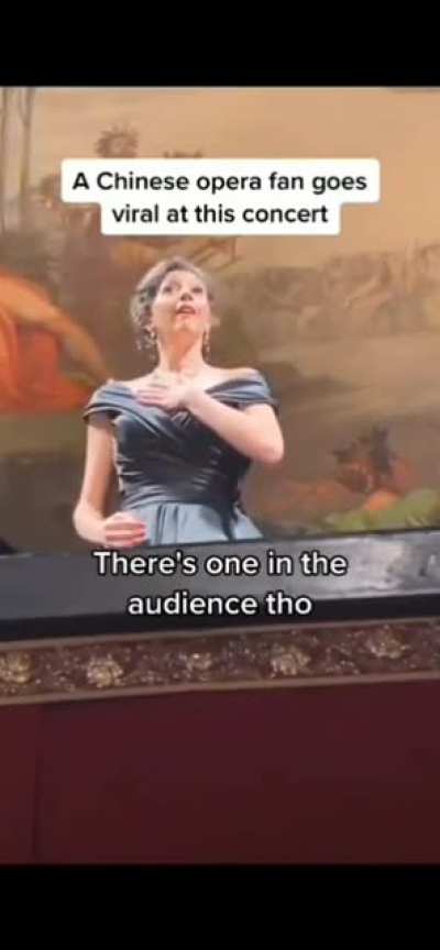 An audience member joins in at the male tenor part of an opera concert.