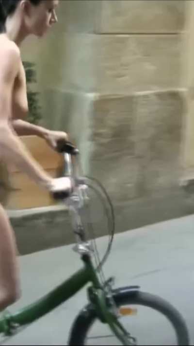 A cute girl rented a bike to ride around the city naked and sunbathe naked on the beach.