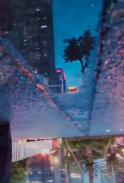 The city reflecting in this puddle