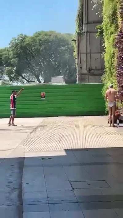 Un hincha de chacarita explicándole a un yanki que no se puede bañar en el medio de aeroparque 