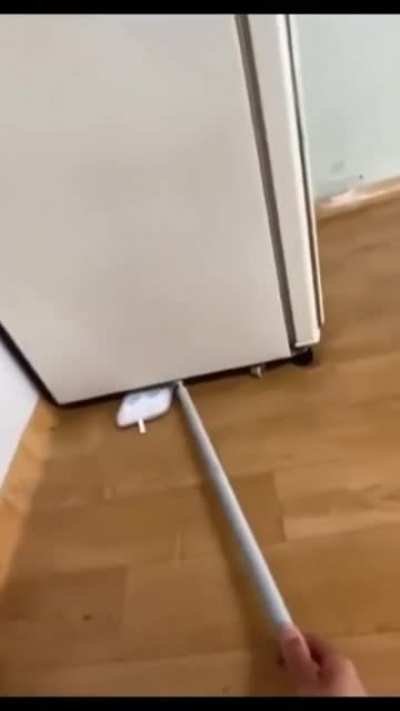 How to properly use a mop to clean under a refrigerator.