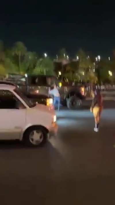 A protestor bangs on a car window and then got pushed to the ground