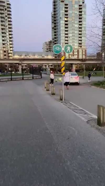 Person driving on the pedestrian path along the seawall in Vancouver Canada